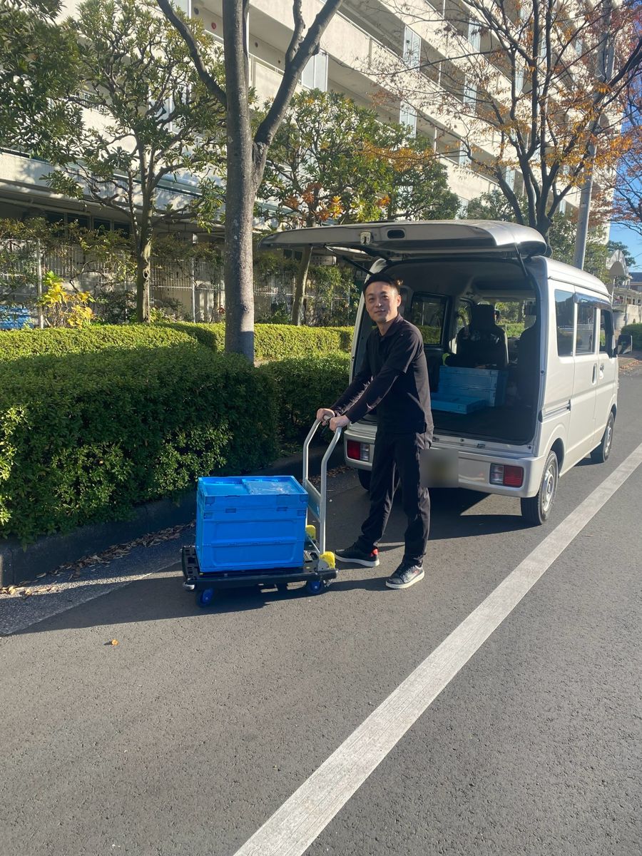 台車で荷物を運ぶドライバー